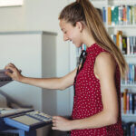 A teacher uses a multifunction printer at her school