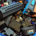 A pile of used ink and toner cartridges